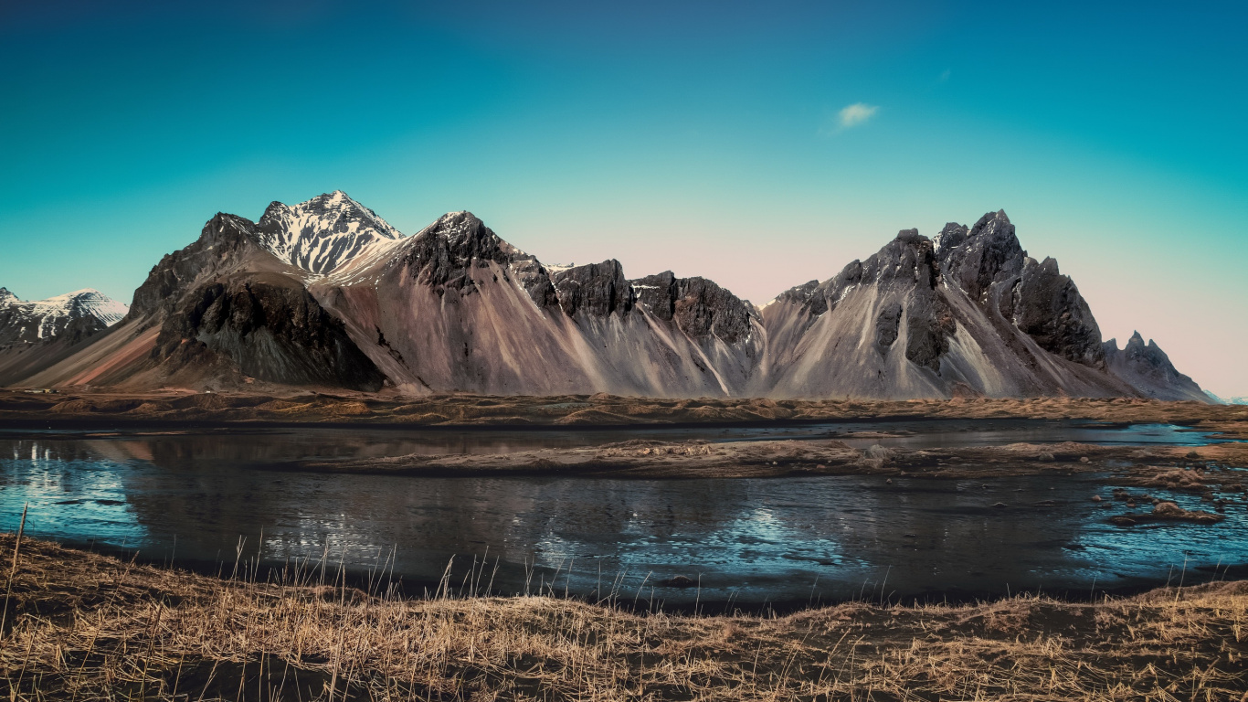Brown and White Mountains Near Lake Under Blue Sky During Daytime. Wallpaper in 1366x768 Resolution