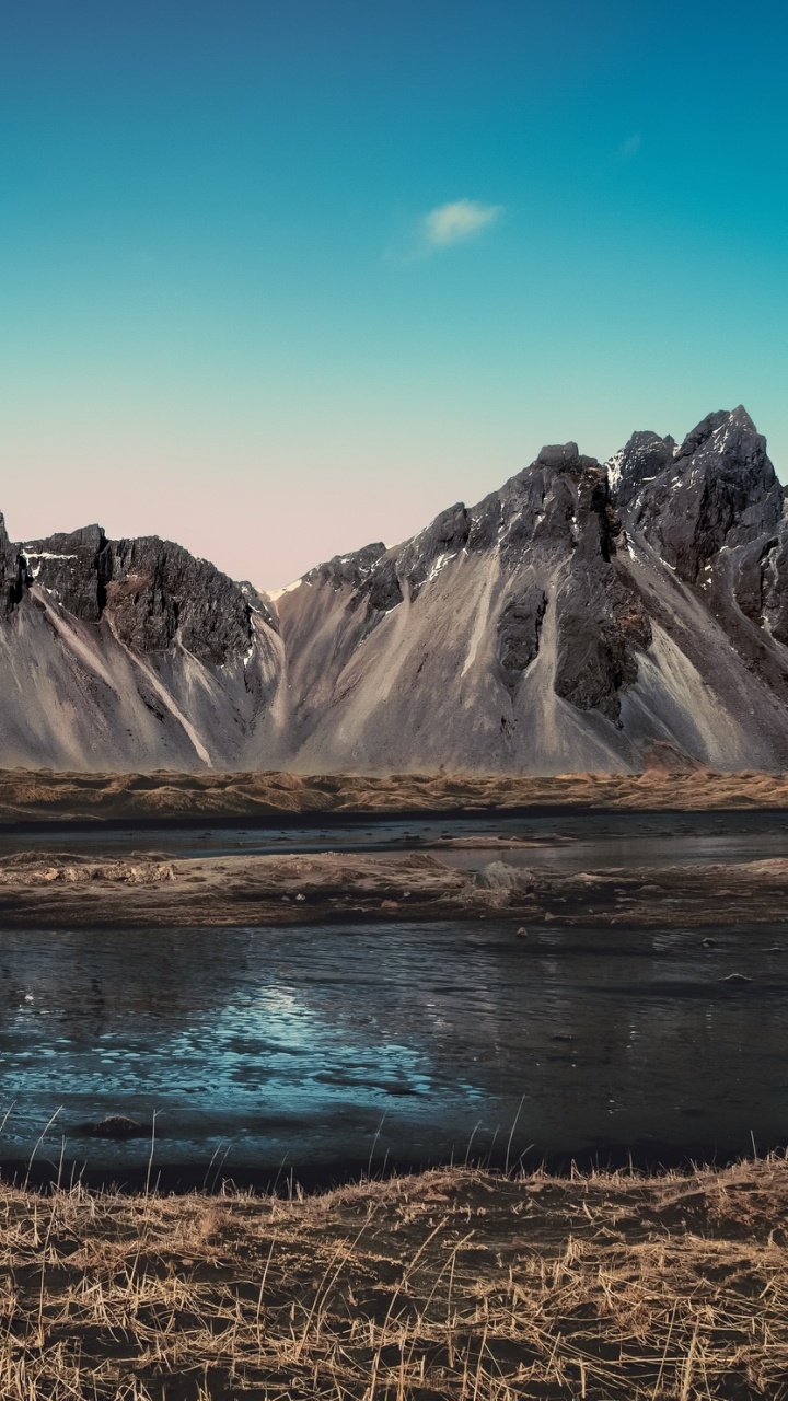 Brown and White Mountains Near Lake Under Blue Sky During Daytime. Wallpaper in 720x1280 Resolution