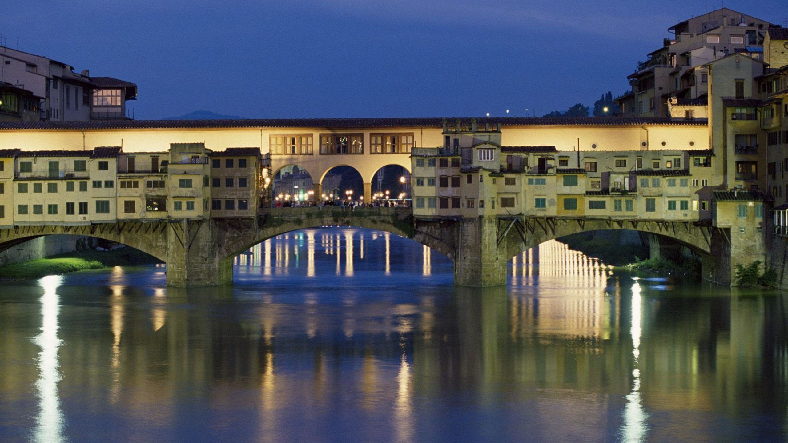 Brown Concrete Bridge Over River During Night Time. Wallpaper in 2560x1440 Resolution