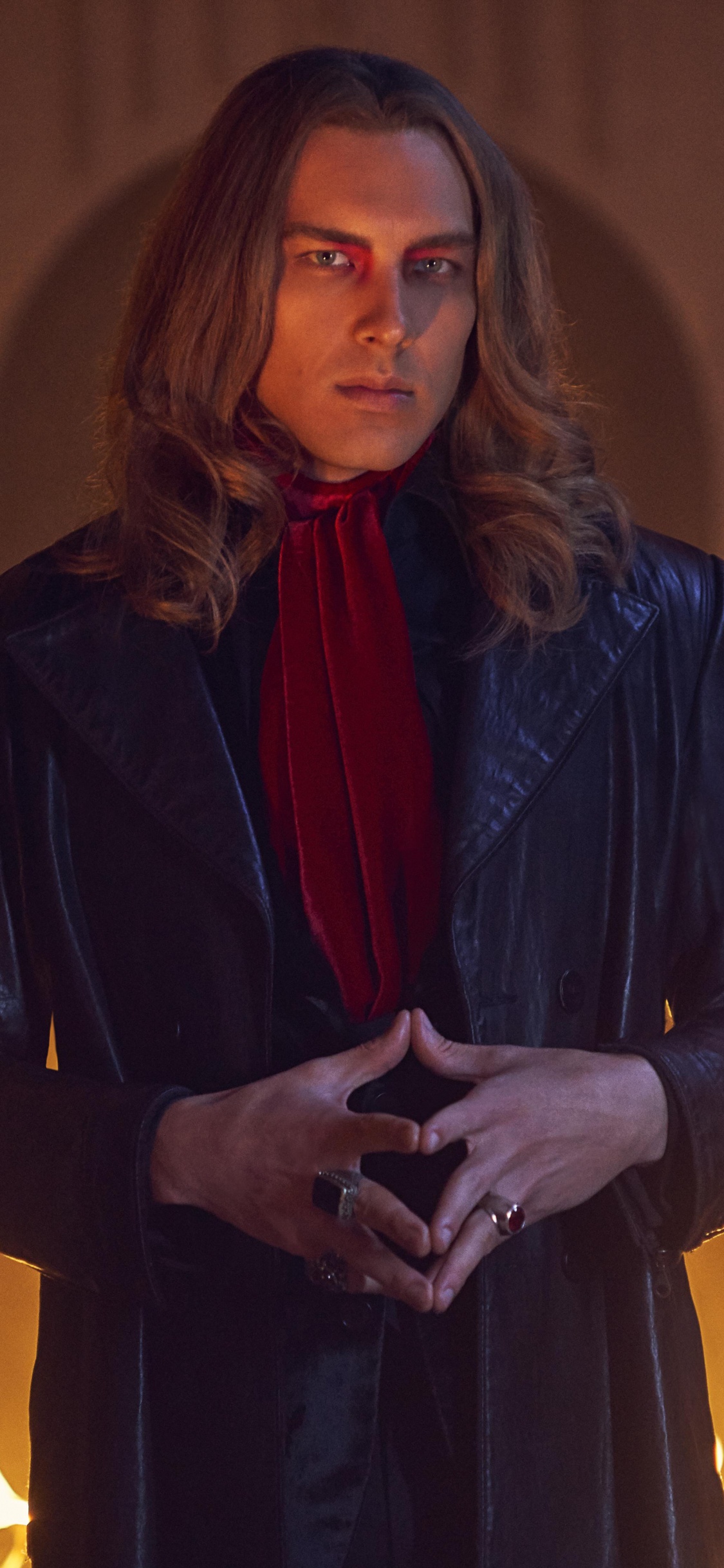 Woman in Black Coat Holding Lighted Candle. Wallpaper in 1125x2436 Resolution