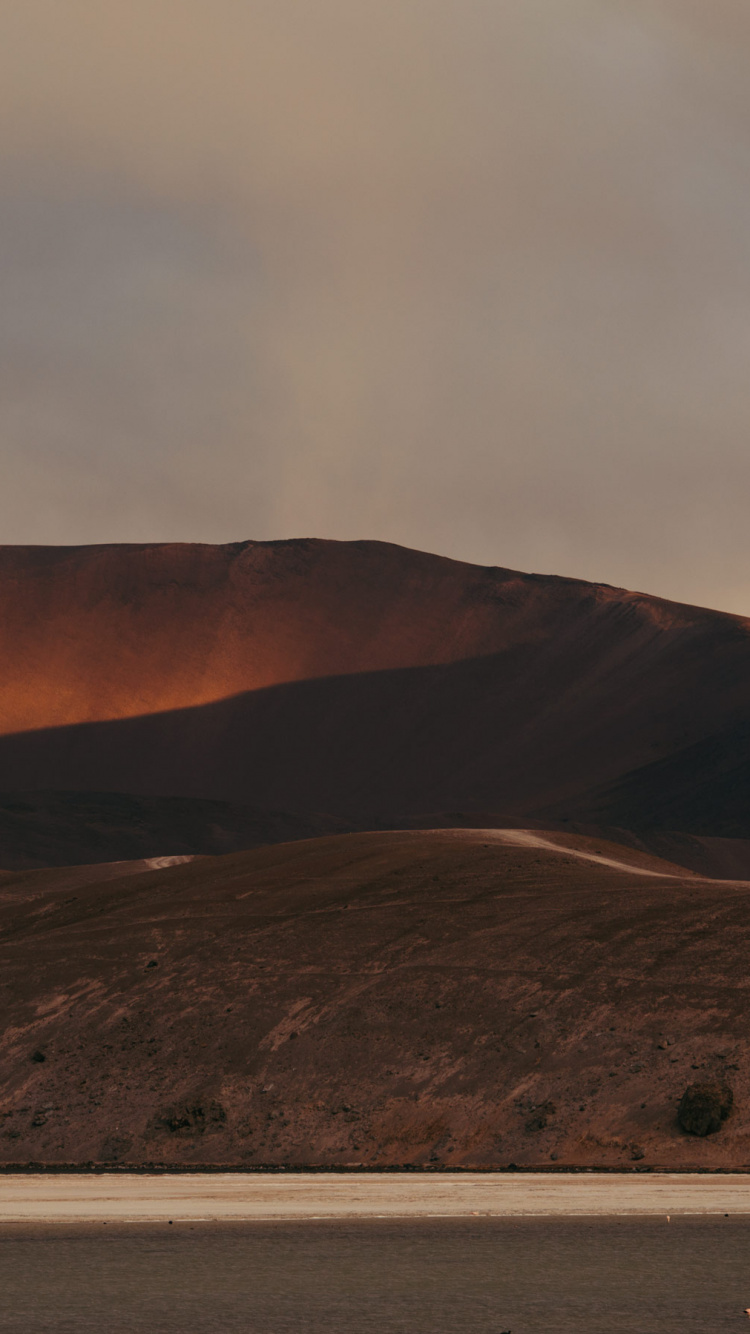 Brown Mountain Under White Sky During Daytime. Wallpaper in 750x1334 Resolution