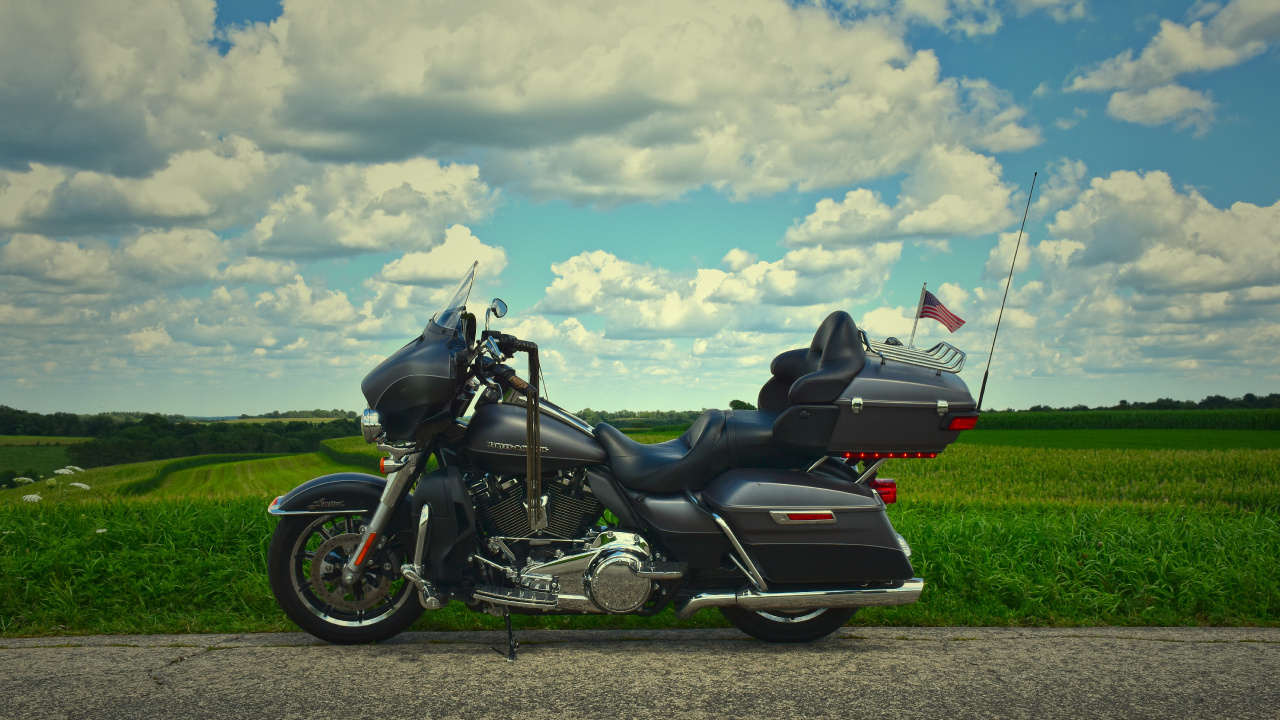 Black and White Sports Bike on Green Grass Field Under White Clouds and Blue Sky During. Wallpaper in 1280x720 Resolution