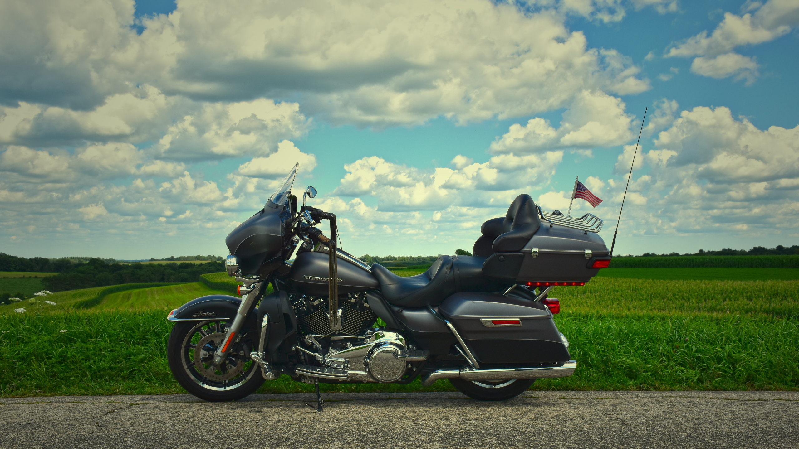 Black and White Sports Bike on Green Grass Field Under White Clouds and Blue Sky During. Wallpaper in 2560x1440 Resolution