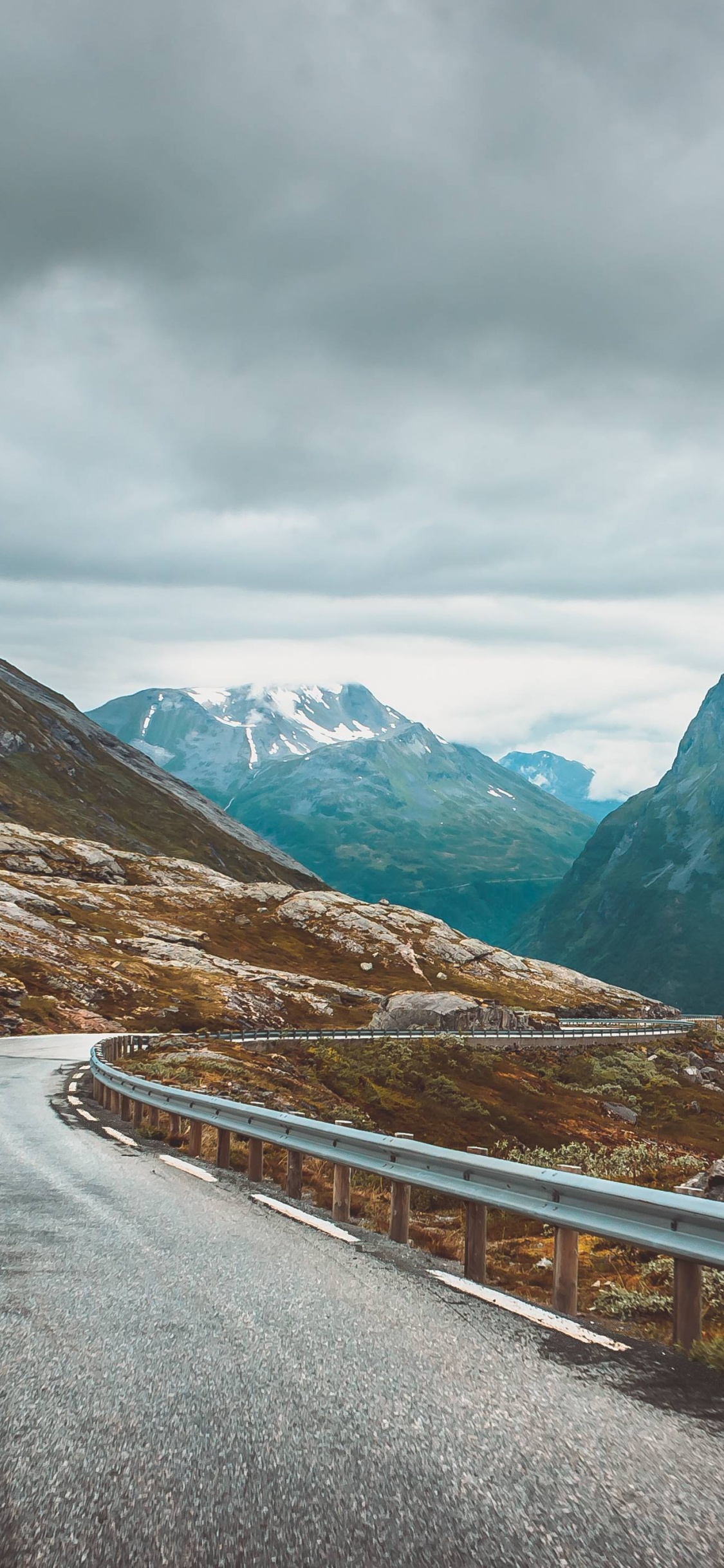 Gray Concrete Road Near Mountains During Daytime. Wallpaper in 1125x2436 Resolution