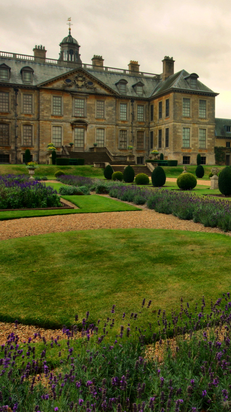 Champ D'herbe Verte Près D'un Bâtiment en Béton Brun Pendant la Journée. Wallpaper in 750x1334 Resolution