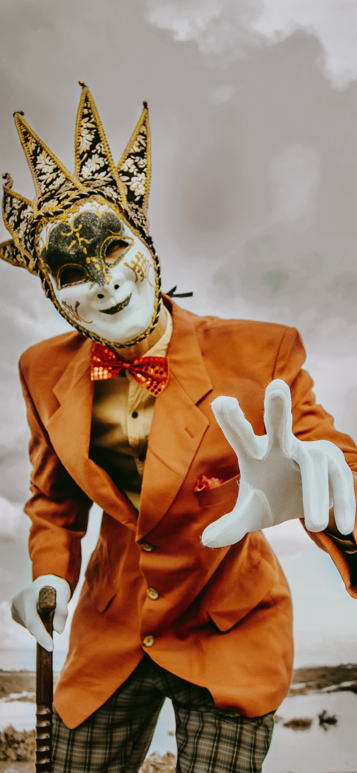 Personne en Costume Orange Avec Masque Blanc. Wallpaper in 1242x2688 Resolution