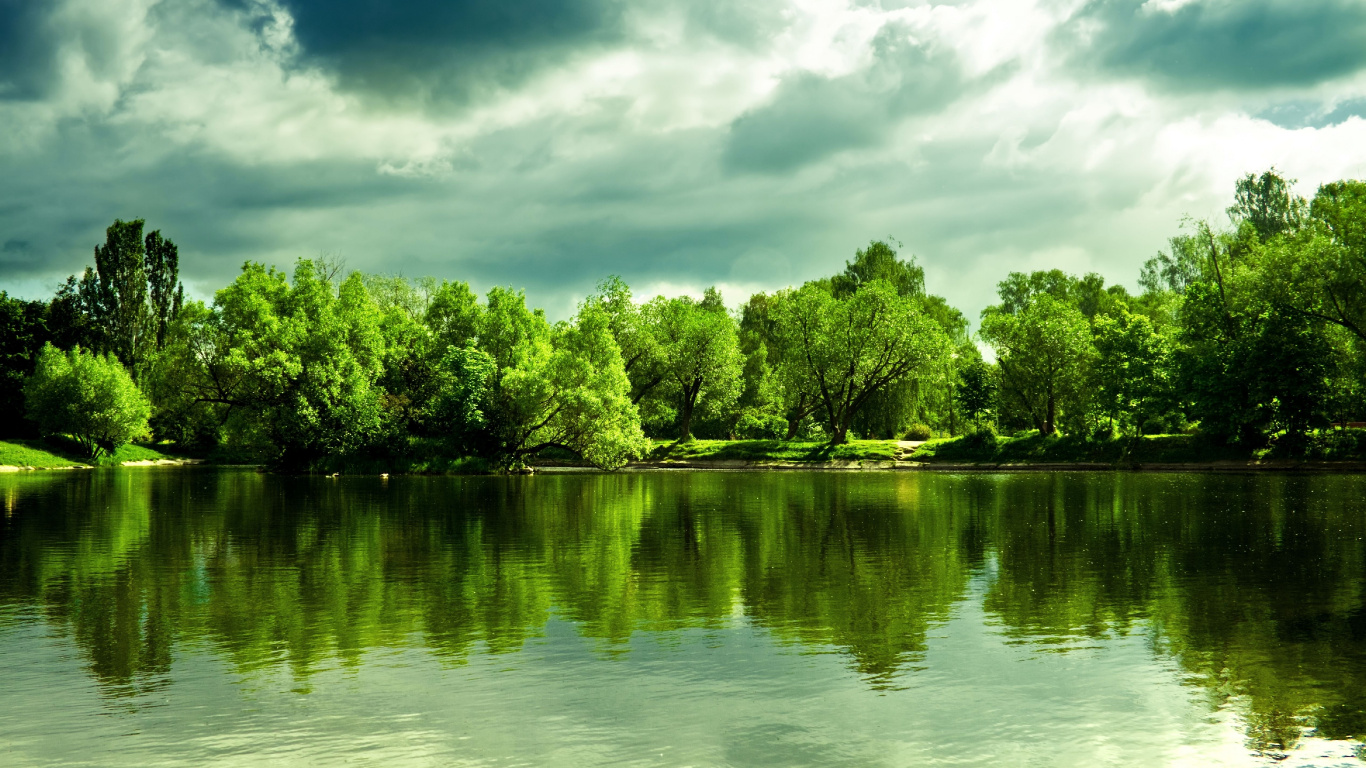 Green Trees Beside River Under Cloudy Sky During Daytime. Wallpaper in 1366x768 Resolution