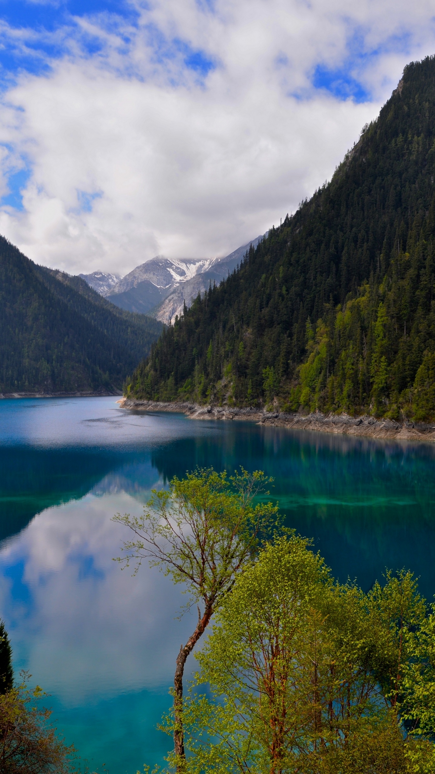 Green Mountains Beside Lake Under Blue Sky and White Clouds During Daytime. Wallpaper in 1440x2560 Resolution