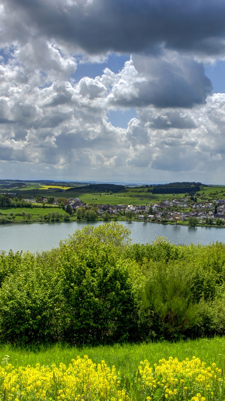 Campo de Hierba Verde Cerca Del Lago Bajo un Cielo Nublado Durante el Día. Wallpaper in 720x1280 Resolution