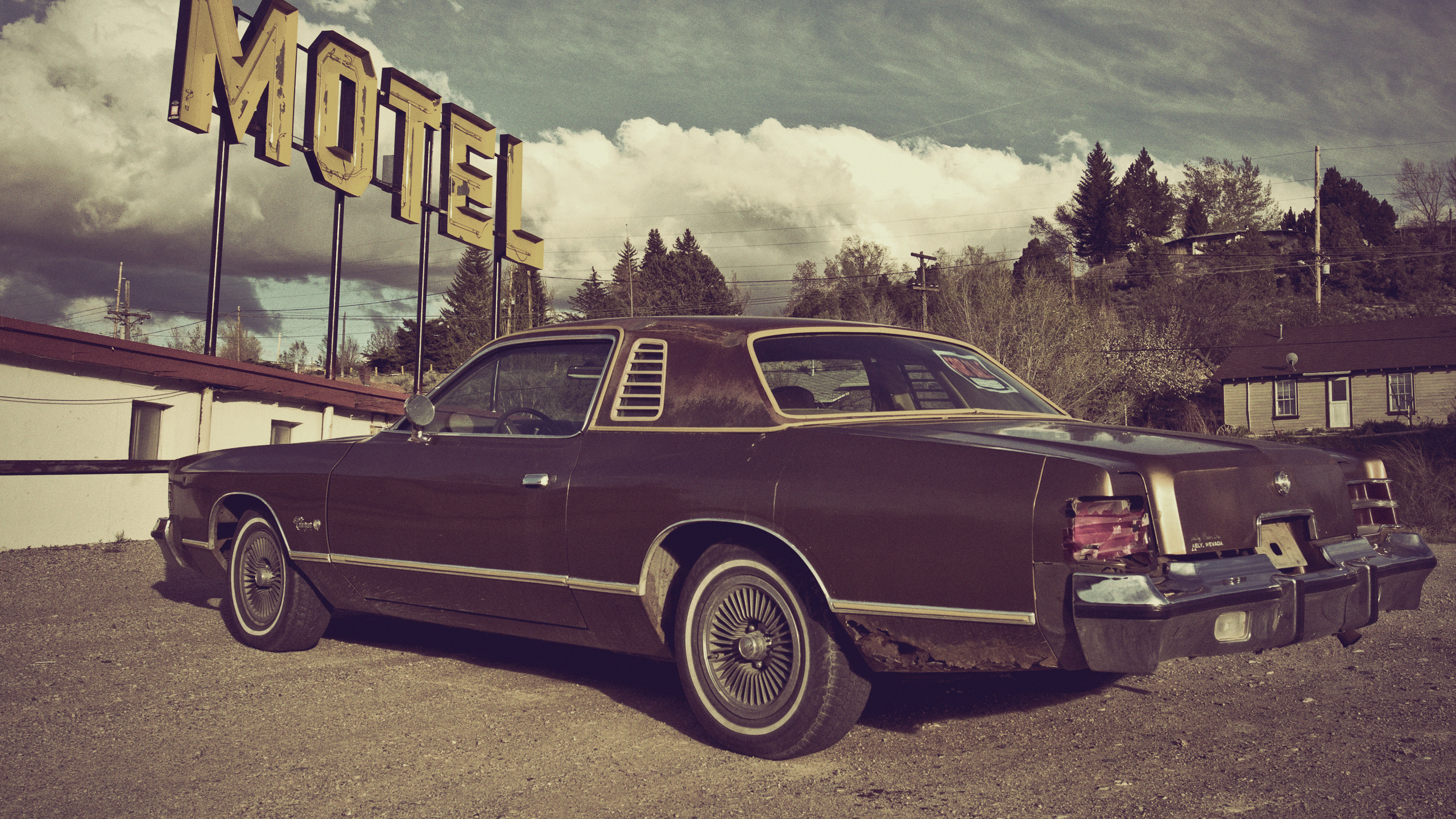 Red Sedan Parked on Gray Concrete Road Under Gray Clouds. Wallpaper in 2560x1440 Resolution