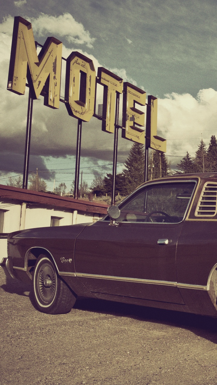 Red Sedan Parked on Gray Concrete Road Under Gray Clouds. Wallpaper in 720x1280 Resolution