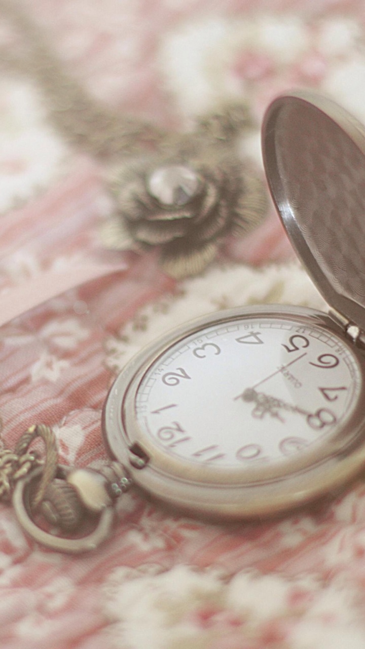 Gold Pocket Watch on Pink and White Floral Textile. Wallpaper in 720x1280 Resolution