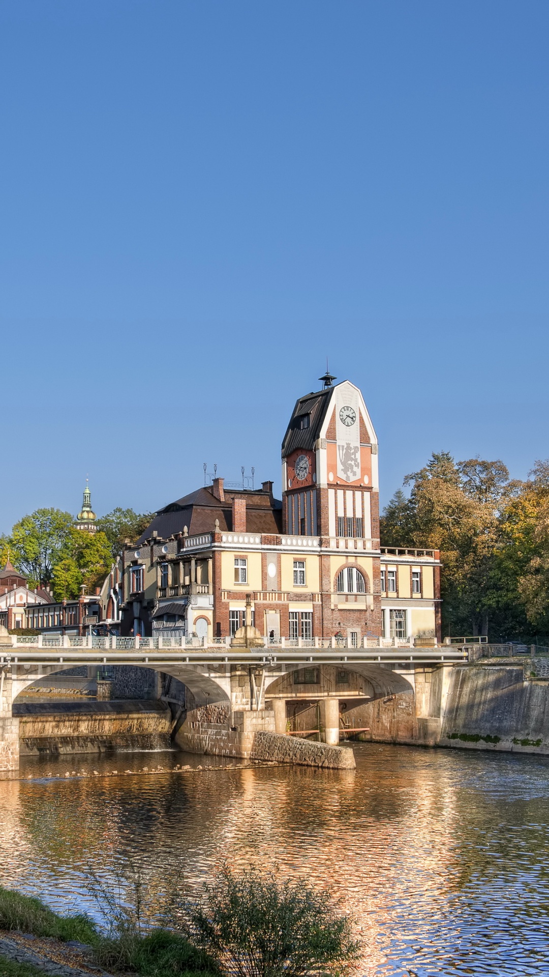 Braunes Und Weißes Betongebäude in Der Nähe Von Gewässern Unter Blauem Himmel Tagsüber. Wallpaper in 1080x1920 Resolution