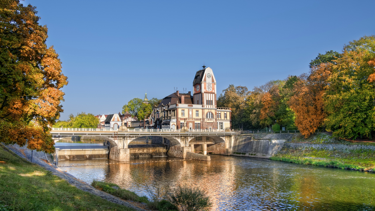 Bâtiment en Béton Marron et Blanc Près D'un Plan D'eau Sous un Ciel Bleu Pendant la Journée. Wallpaper in 1280x720 Resolution
