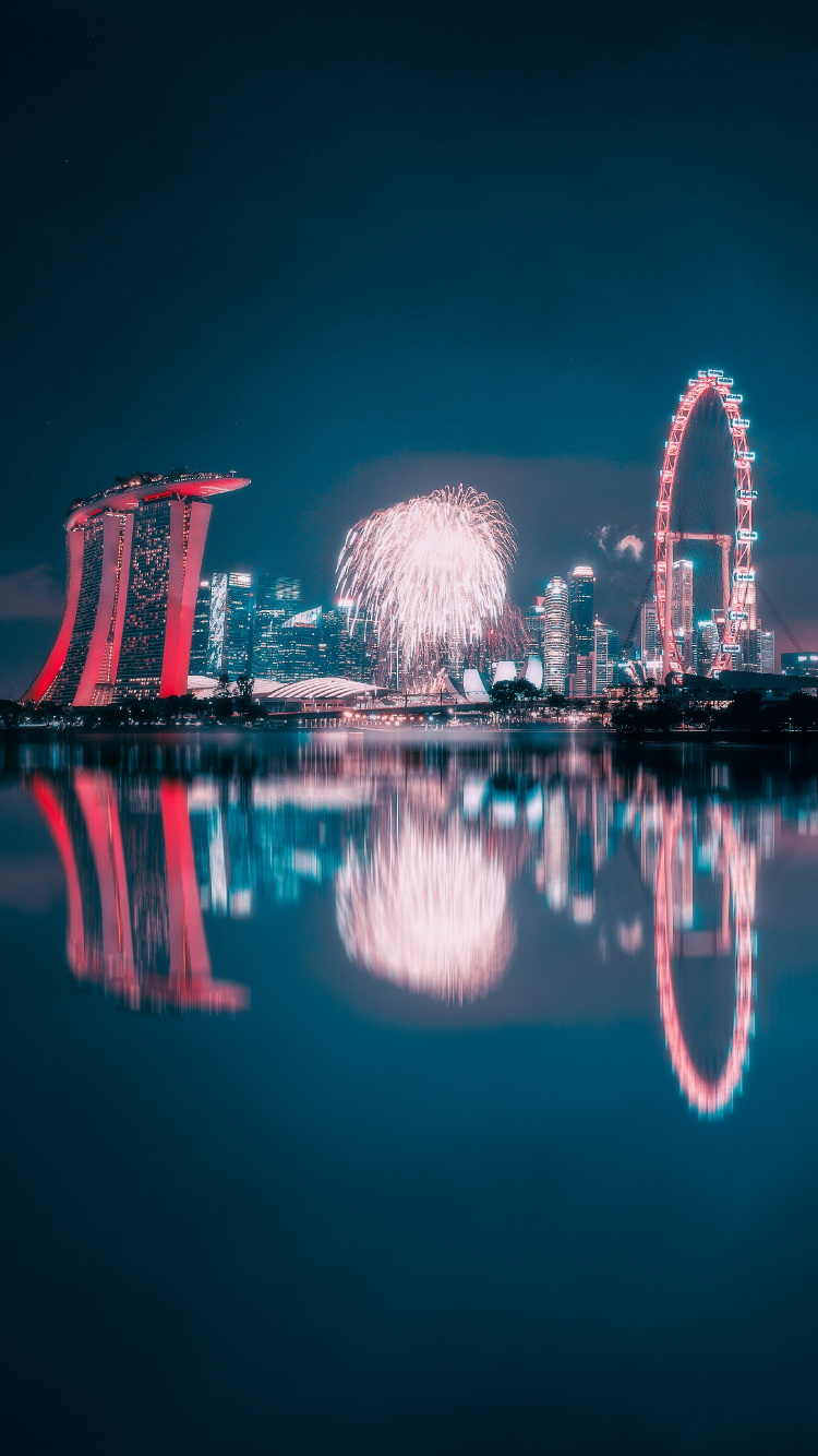 Feu D'artifice Au-dessus D'un Plan D'eau Pendant la Nuit. Wallpaper in 750x1334 Resolution