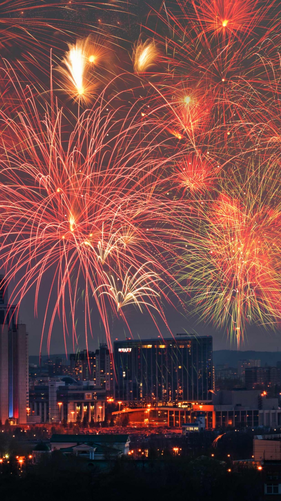 Fireworks Display Over City Buildings During Night Time. Wallpaper in 1080x1920 Resolution