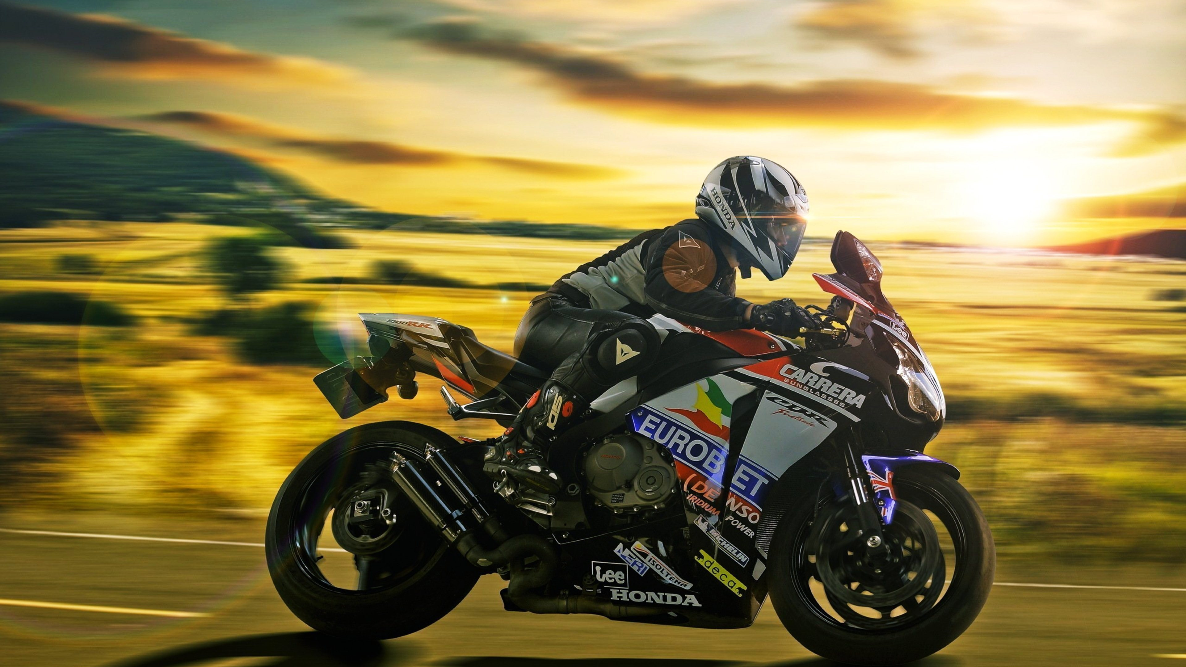 Man in Black and White Motorcycle Suit Riding on Black and Yellow Sports Bike. Wallpaper in 3840x2160 Resolution