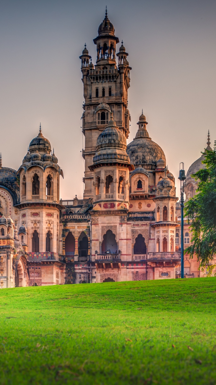 Braunes Betongebäude Auf Grünem Grasfeld Tagsüber. Wallpaper in 750x1334 Resolution