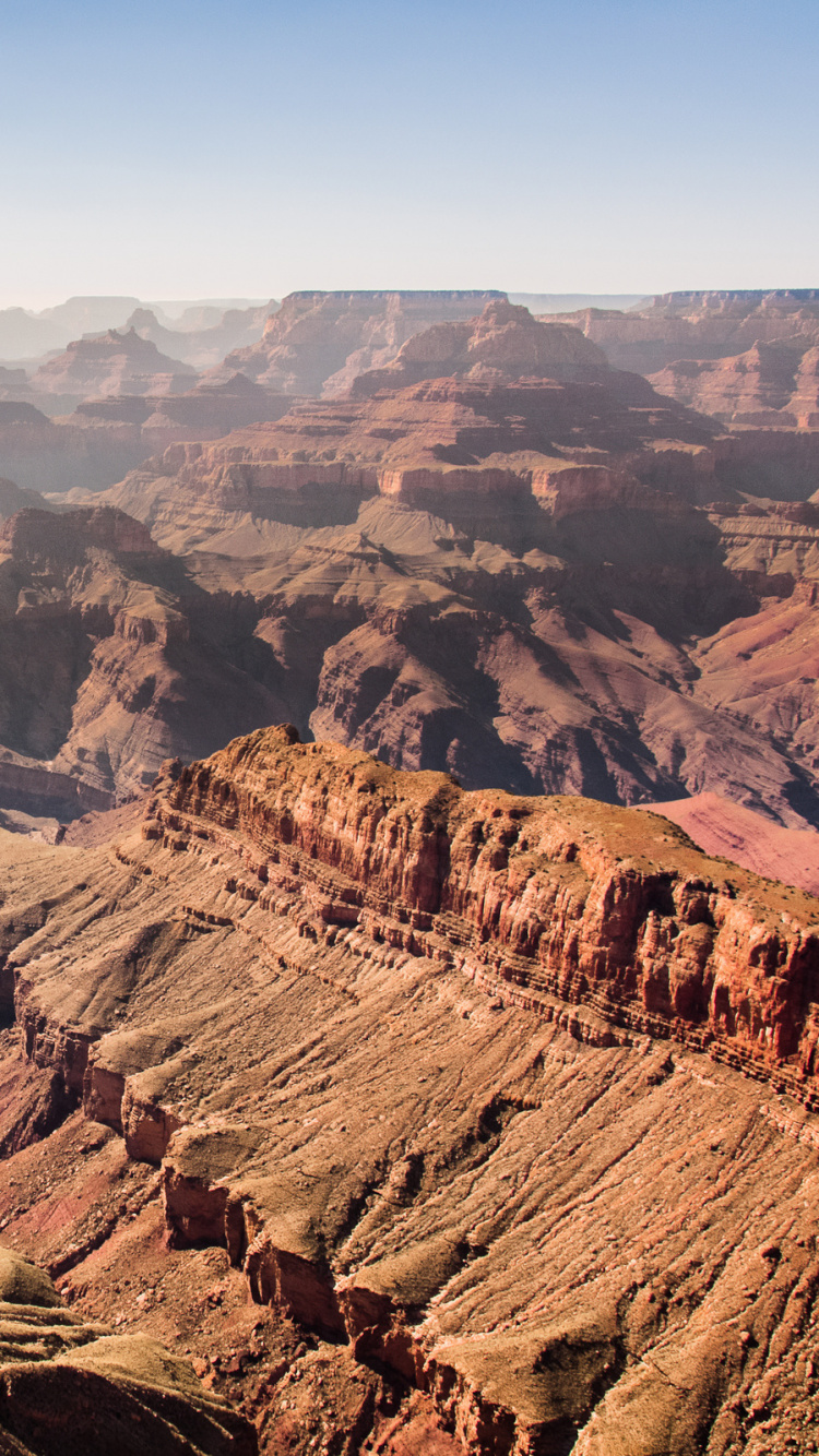 Montaña Rocosa Marrón Bajo un Cielo Azul Durante el Día. Wallpaper in 750x1334 Resolution