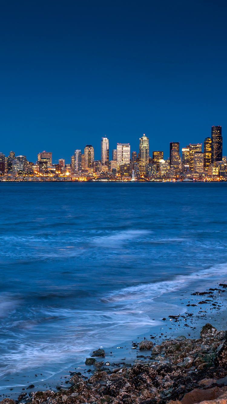 Horizonte de la Ciudad a Través Del Cuerpo de Agua Durante el Día.. Wallpaper in 750x1334 Resolution