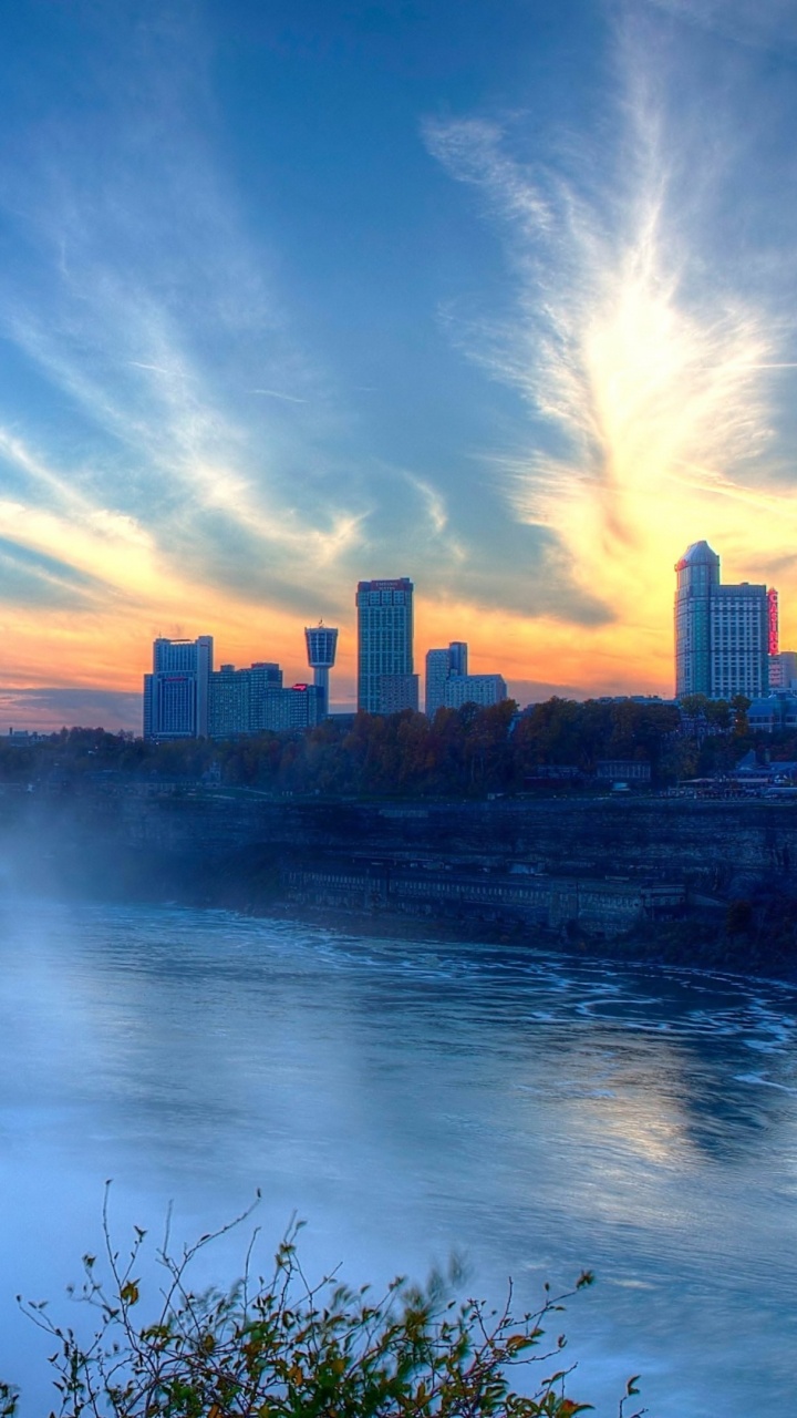 Water Falls Near High Rise Buildings Under Blue Sky During Daytime. Wallpaper in 720x1280 Resolution
