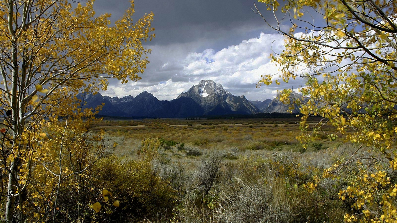 Campo de Hierba Verde Cerca de la Montaña Bajo Nubes Blancas Durante el Día. Wallpaper in 1366x768 Resolution
