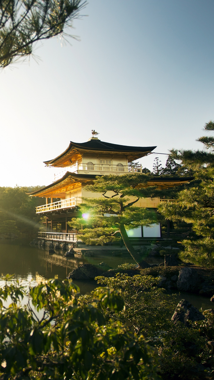 Braunes Und Weißes Haus in Der Nähe Des Sees Tagsüber. Wallpaper in 750x1334 Resolution