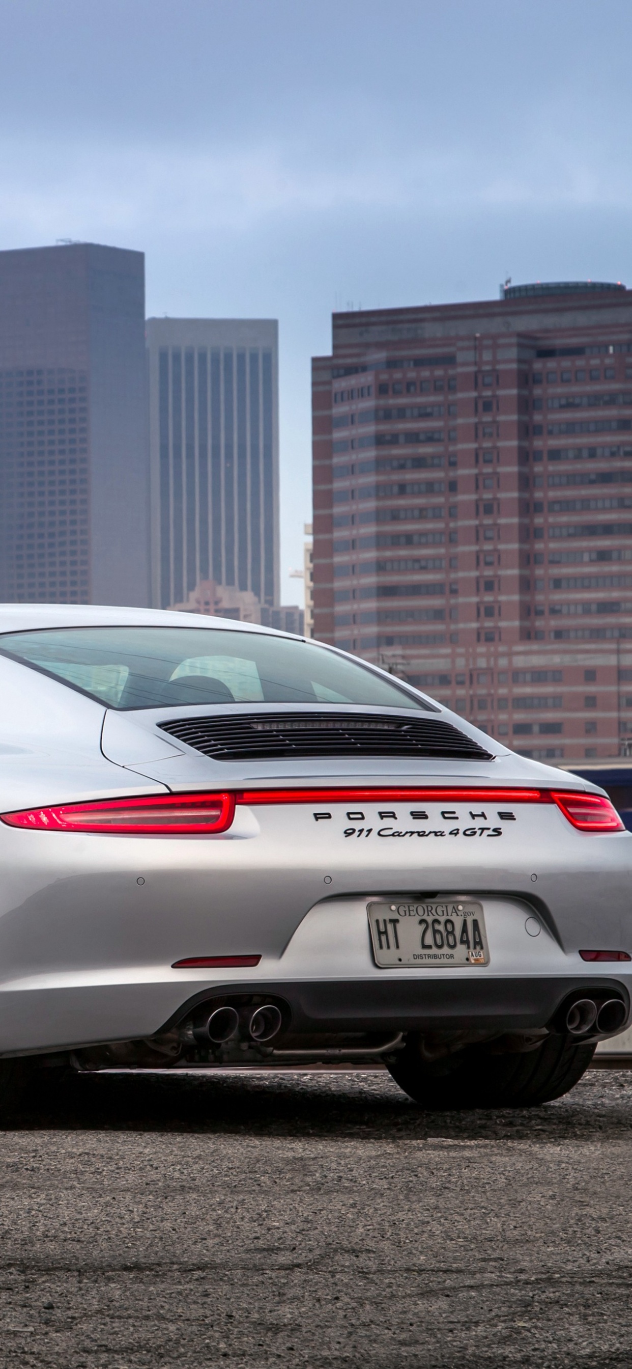 Porsche 911 Blanche Garée Près D'une Clôture Métallique Bleue Pendant la Journée. Wallpaper in 1242x2688 Resolution