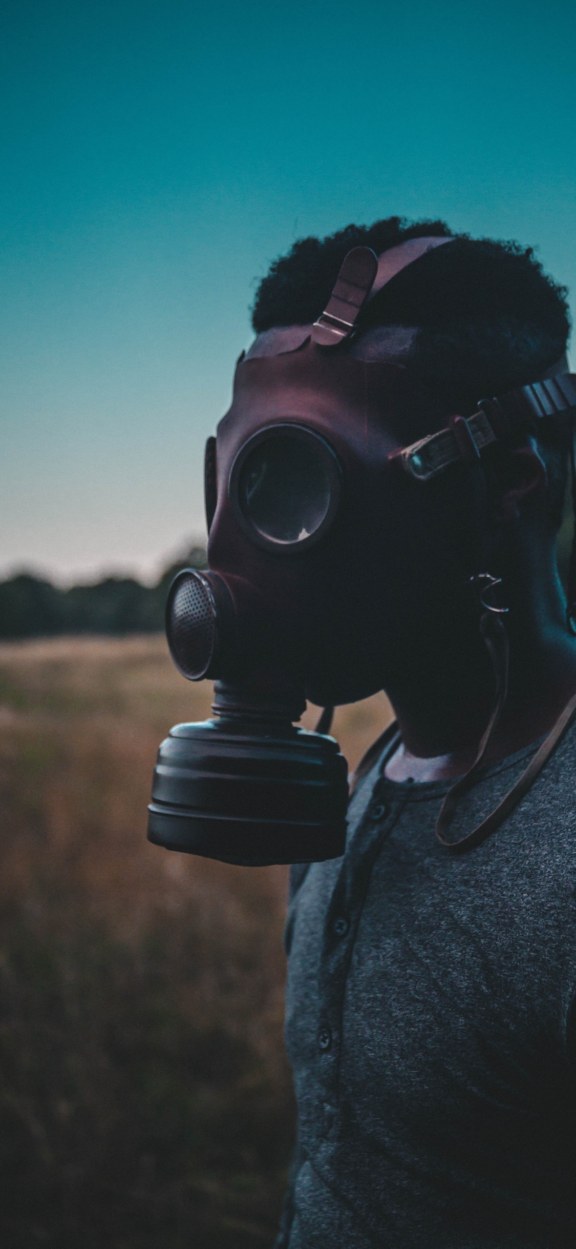 Man in Gray Sweater Wearing Black Gas Mask. Wallpaper in 1125x2436 Resolution