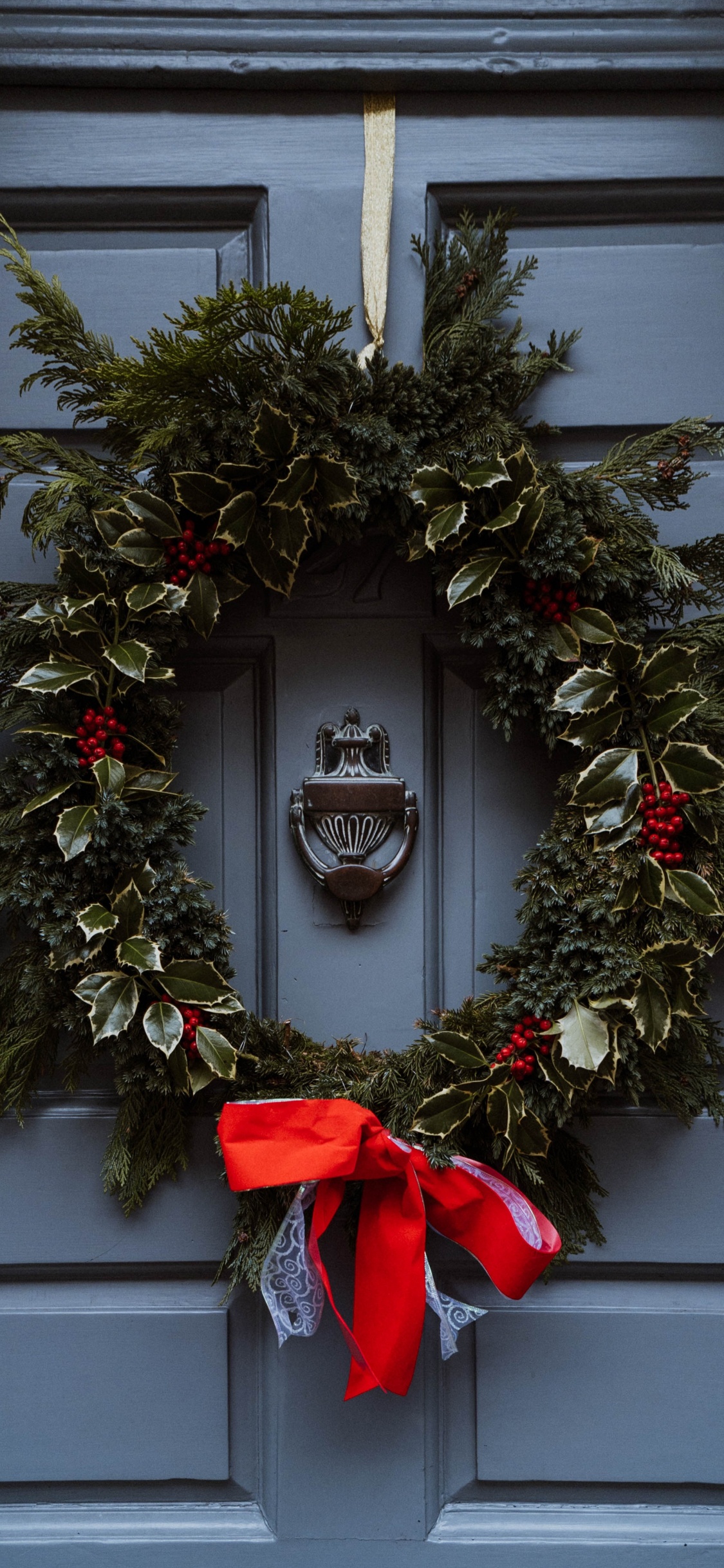 Green and Brown Wreath on White Wooden Door. Wallpaper in 1125x2436 Resolution