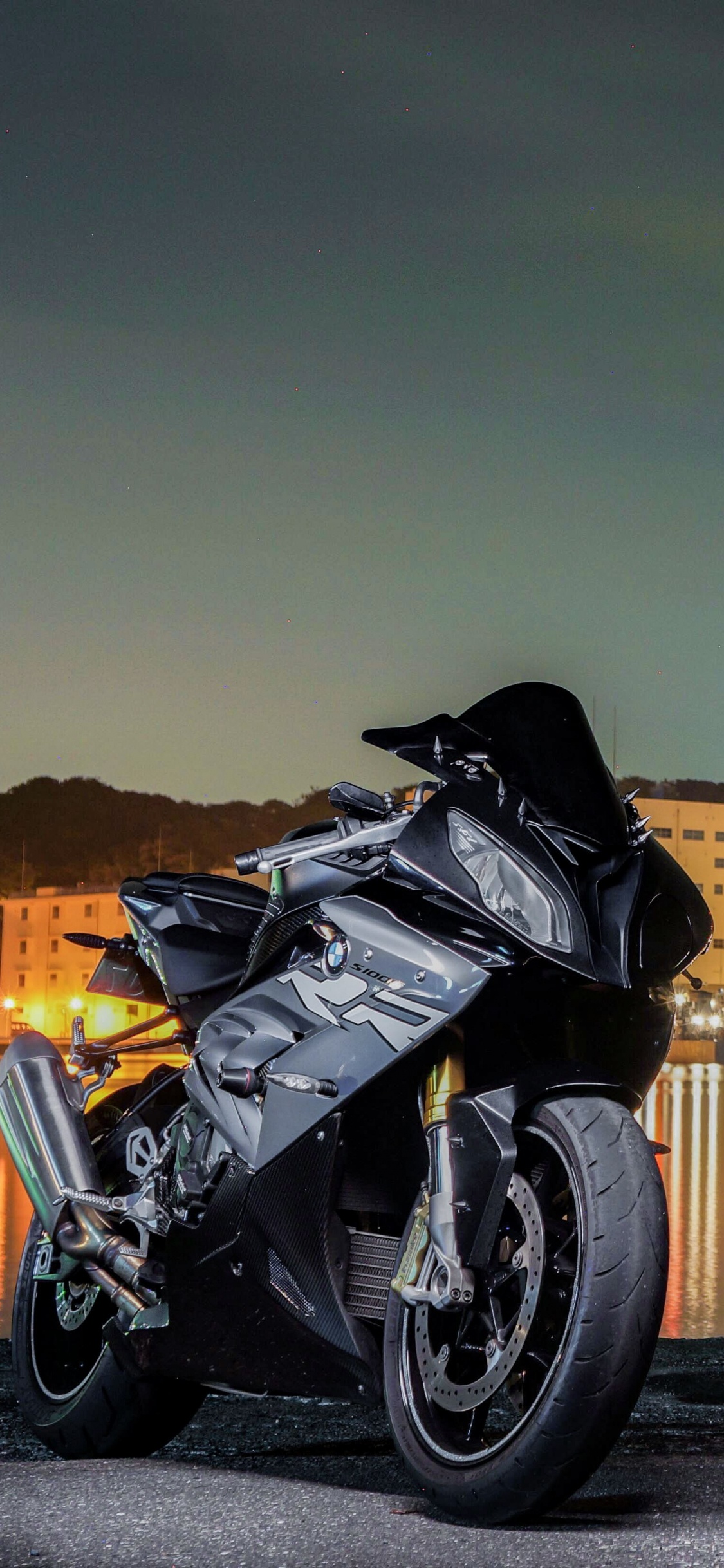 Schwarzes Sportfahrrad, Das Nachts Neben Einem Gewässer Geparkt Ist. Wallpaper in 1125x2436 Resolution