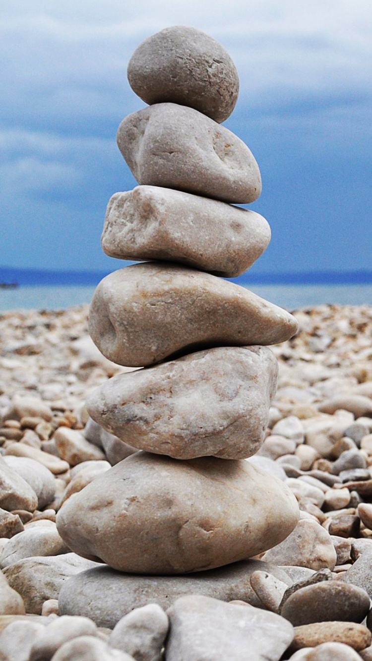 Pierres Grises et Blanches Sur le Rivage de la Plage Pendant la Journée. Wallpaper in 750x1334 Resolution