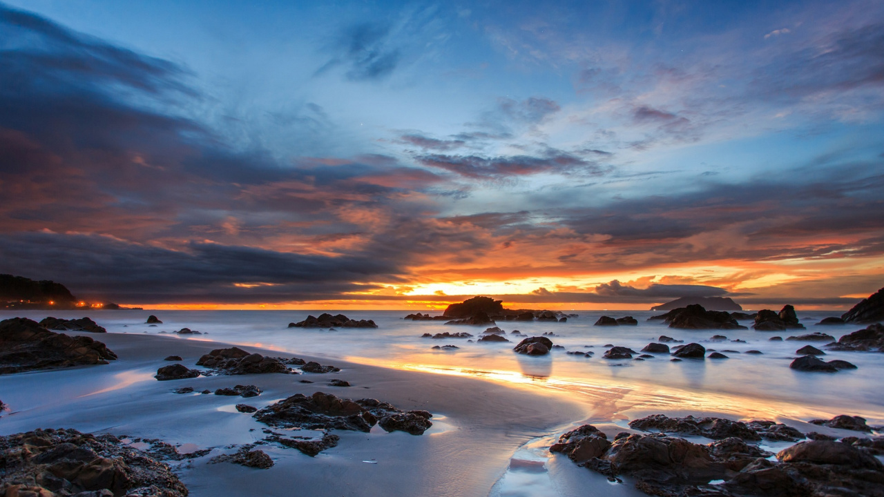 Rocky Shore Under Cloudy Sky During Sunset. Wallpaper in 1280x720 Resolution