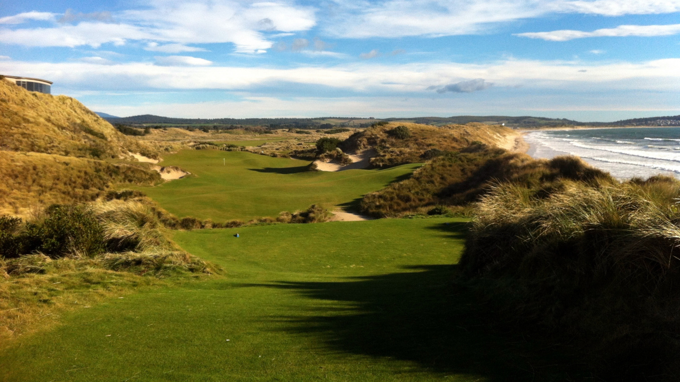 Campo de Hierba Verde Cerca Del Cuerpo de Agua Bajo un Cielo Azul Durante el Día. Wallpaper in 1366x768 Resolution