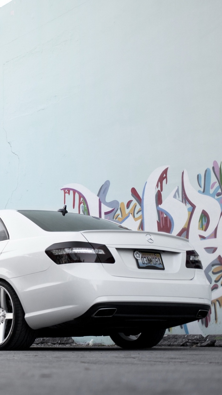 Silver Coupe Parked Beside Wall With Graffiti. Wallpaper in 720x1280 Resolution
