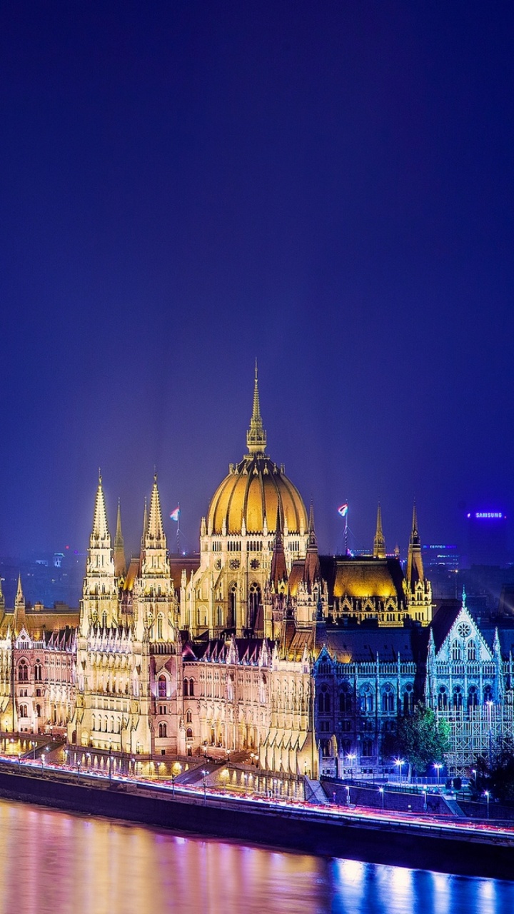 Bâtiment en Béton Brun Près D'un Plan D'eau Pendant la Nuit. Wallpaper in 720x1280 Resolution