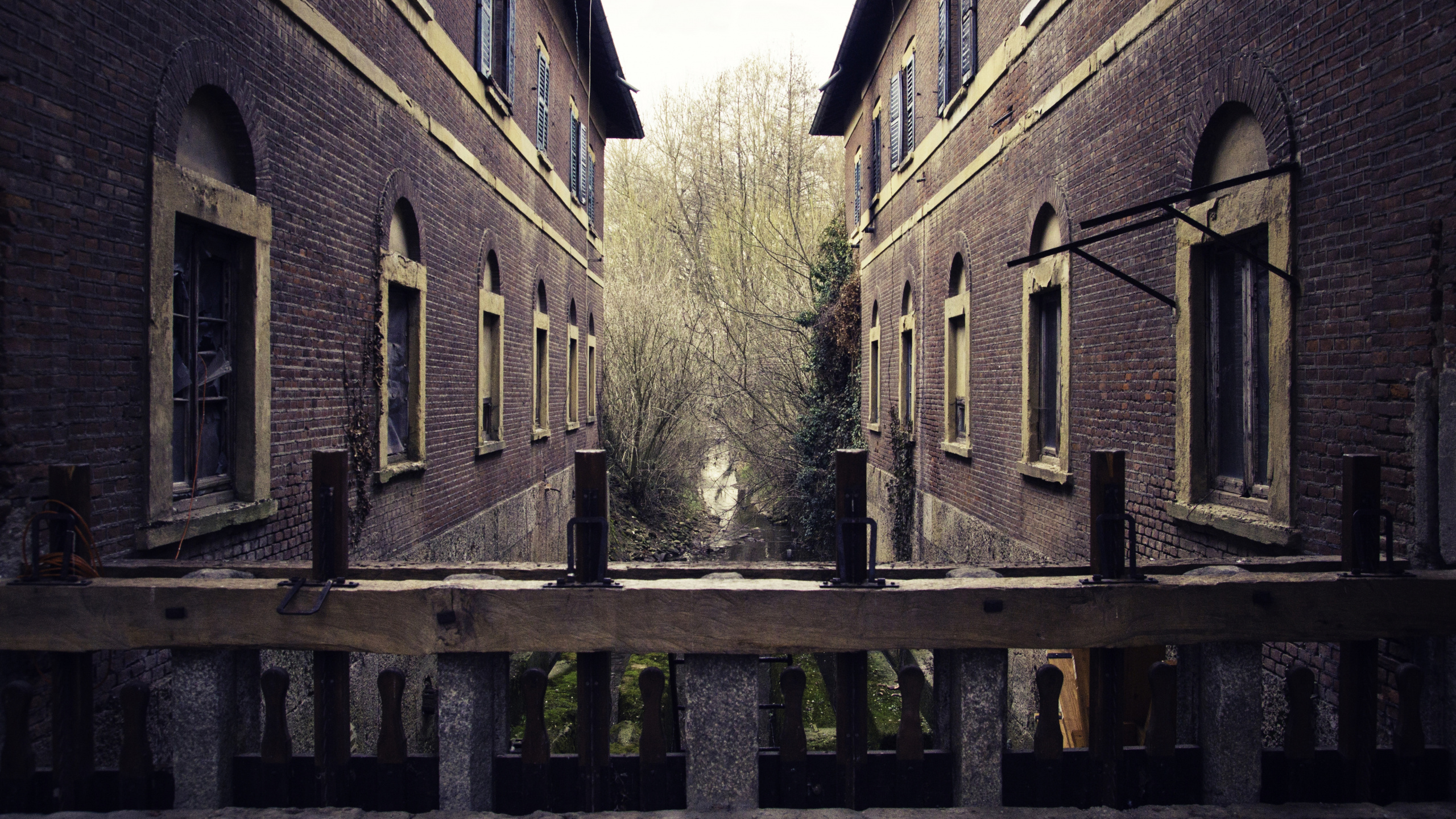 Brown Wooden Fence Near Brown Concrete Building During Daytime. Wallpaper in 2560x1440 Resolution