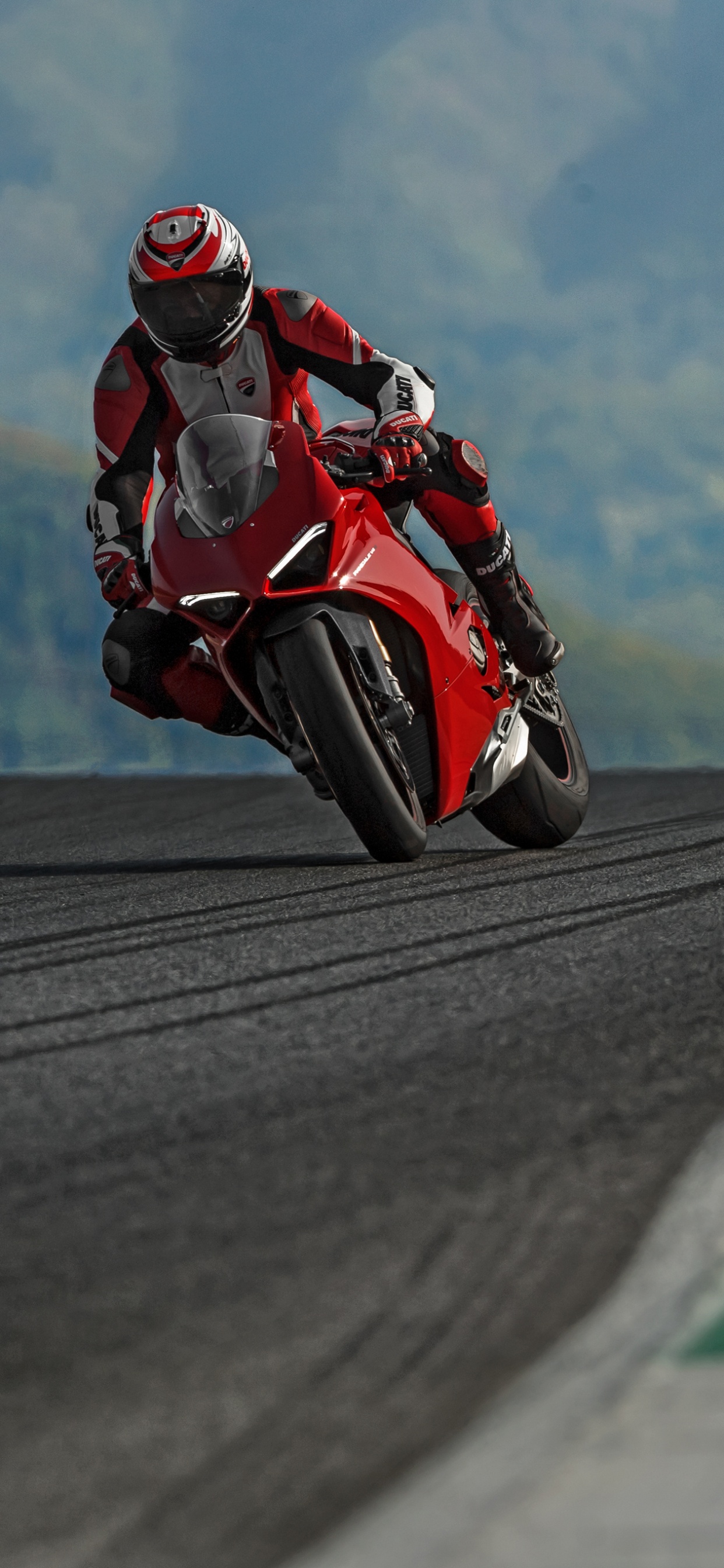 Man in Red and Black Motorcycle Suit Riding on Motorcycle on Road During Daytime. Wallpaper in 1242x2688 Resolution