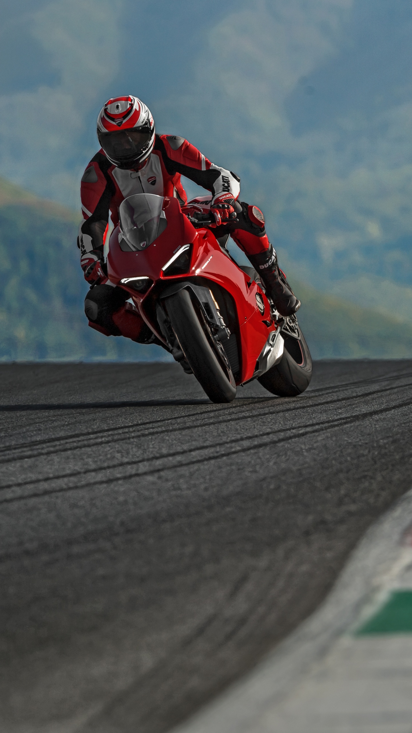 Man in Red and Black Motorcycle Suit Riding on Motorcycle on Road During Daytime. Wallpaper in 1440x2560 Resolution