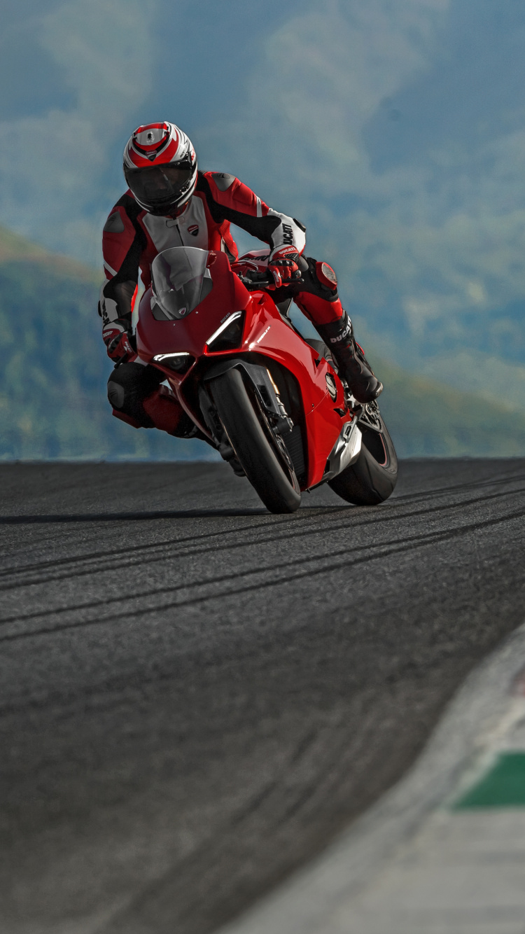 Man in Red and Black Motorcycle Suit Riding on Motorcycle on Road During Daytime. Wallpaper in 750x1334 Resolution