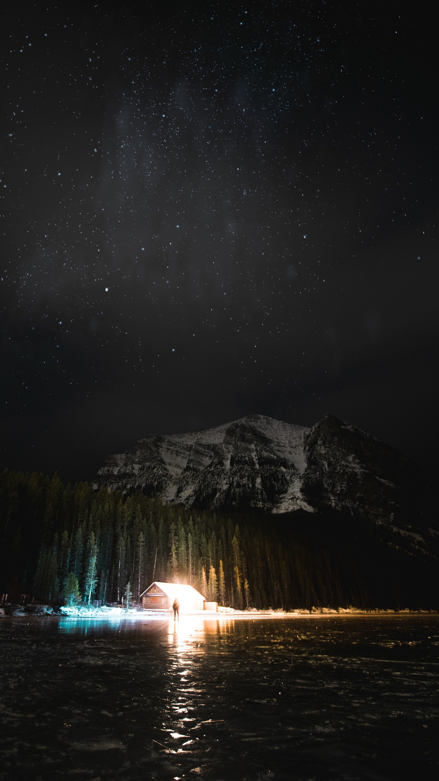 Person Standing on Water Near Mountain During Night Time. Wallpaper in 1440x2560 Resolution