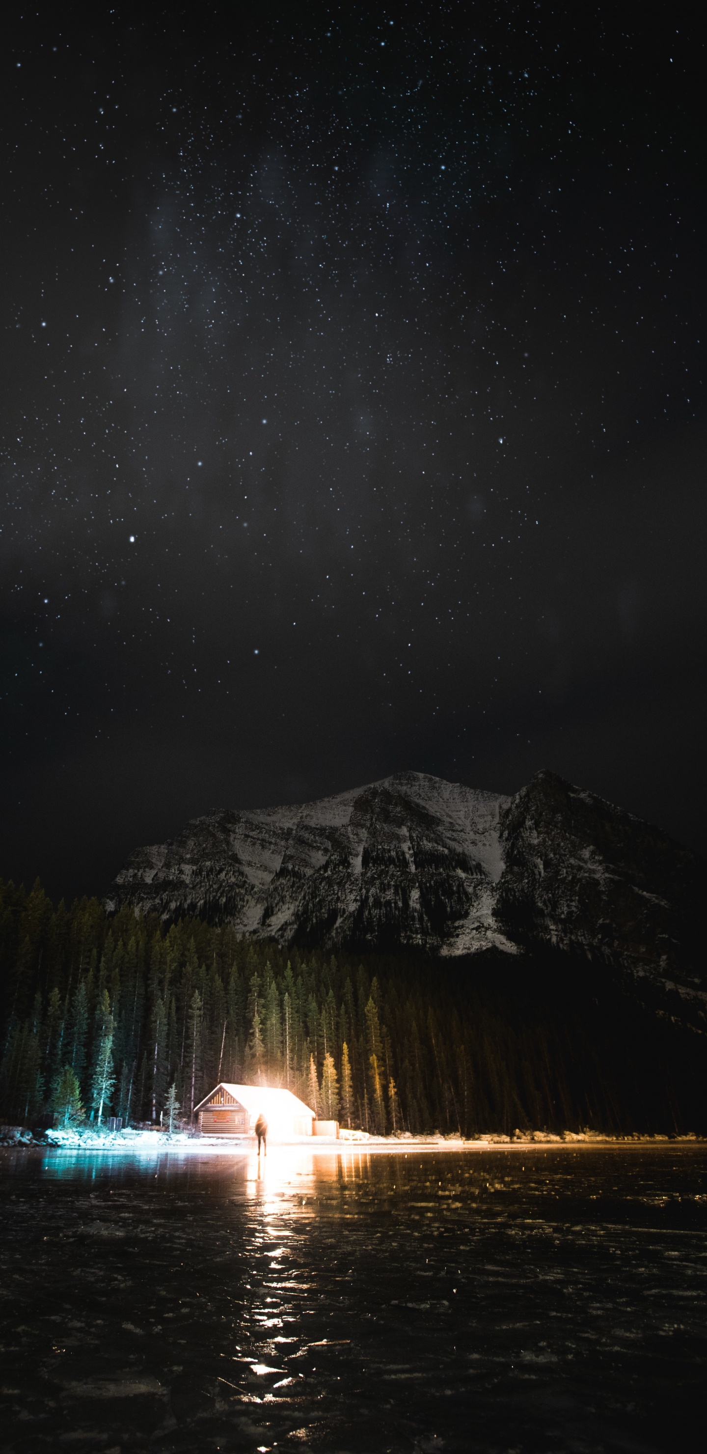 Person Standing on Water Near Mountain During Night Time. Wallpaper in 1440x2960 Resolution