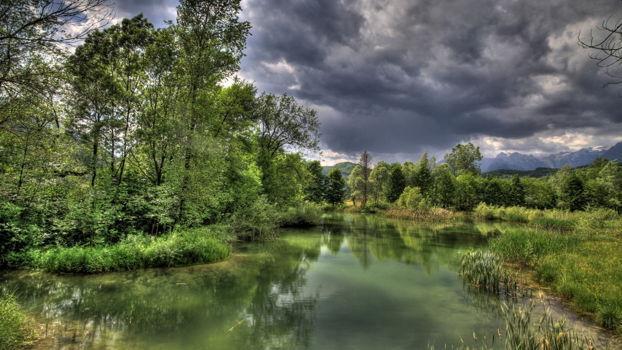 Grüne Bäume Neben Dem Fluss Unter Bewölktem Himmel Tagsüber. Wallpaper in 1280x720 Resolution