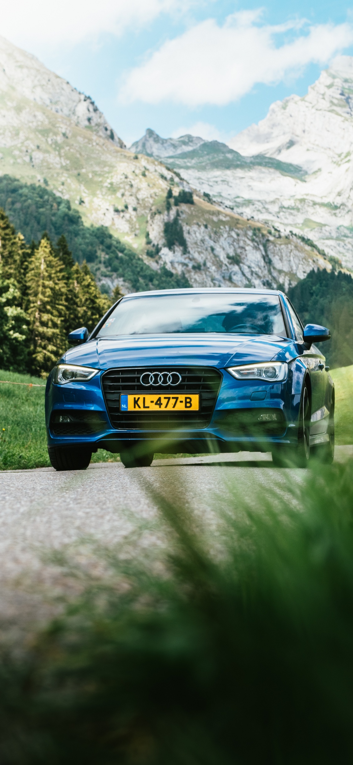 Blue Car on Road Near Green Grass Field and Trees During Daytime. Wallpaper in 1125x2436 Resolution