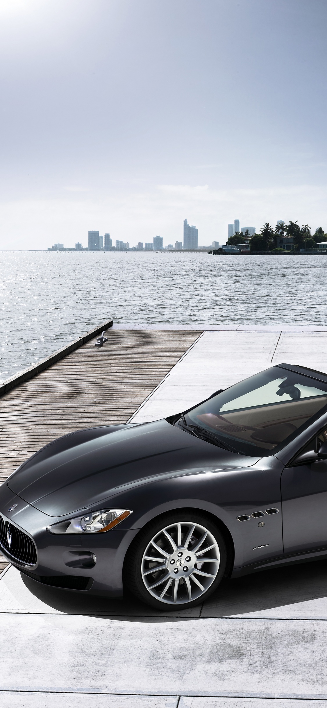 Coupe Convertible Negro Estacionado en el Muelle Durante el Día. Wallpaper in 1125x2436 Resolution