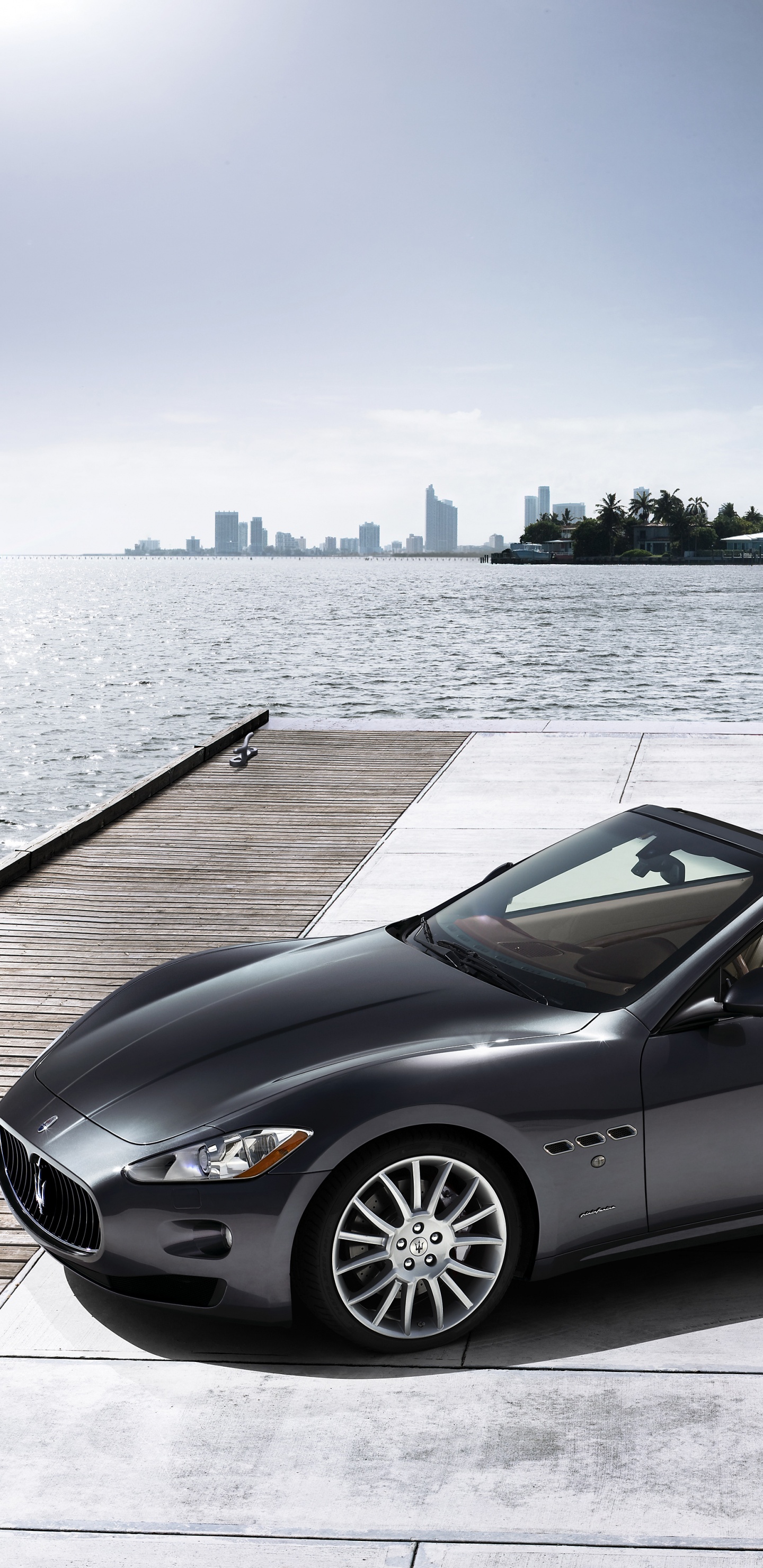 Schwarzes Cabrio-Coupé, Das Tagsüber Auf Dem Dock Geparkt Ist. Wallpaper in 1440x2960 Resolution