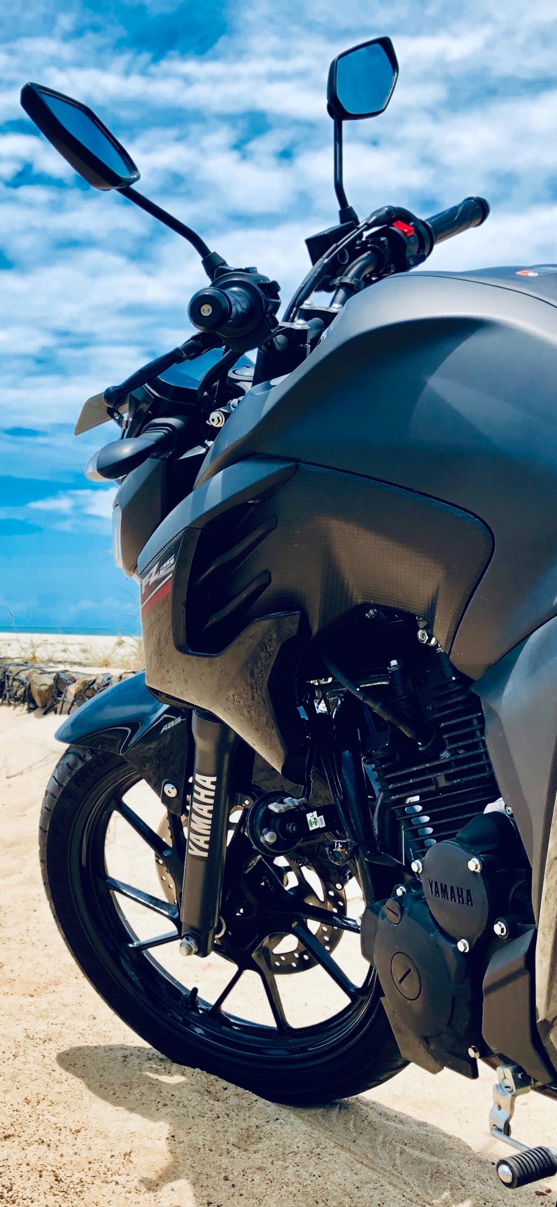 Schwarzes Und Silbernes Motorrad Tagsüber am Strand. Wallpaper in 1125x2436 Resolution