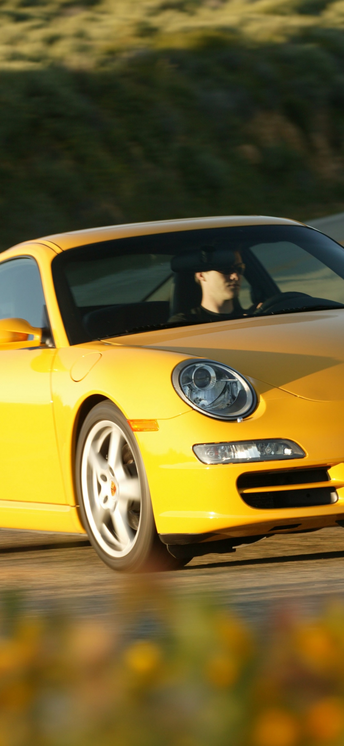 Gelber Porsche 911 Tagsüber Unterwegs. Wallpaper in 1125x2436 Resolution