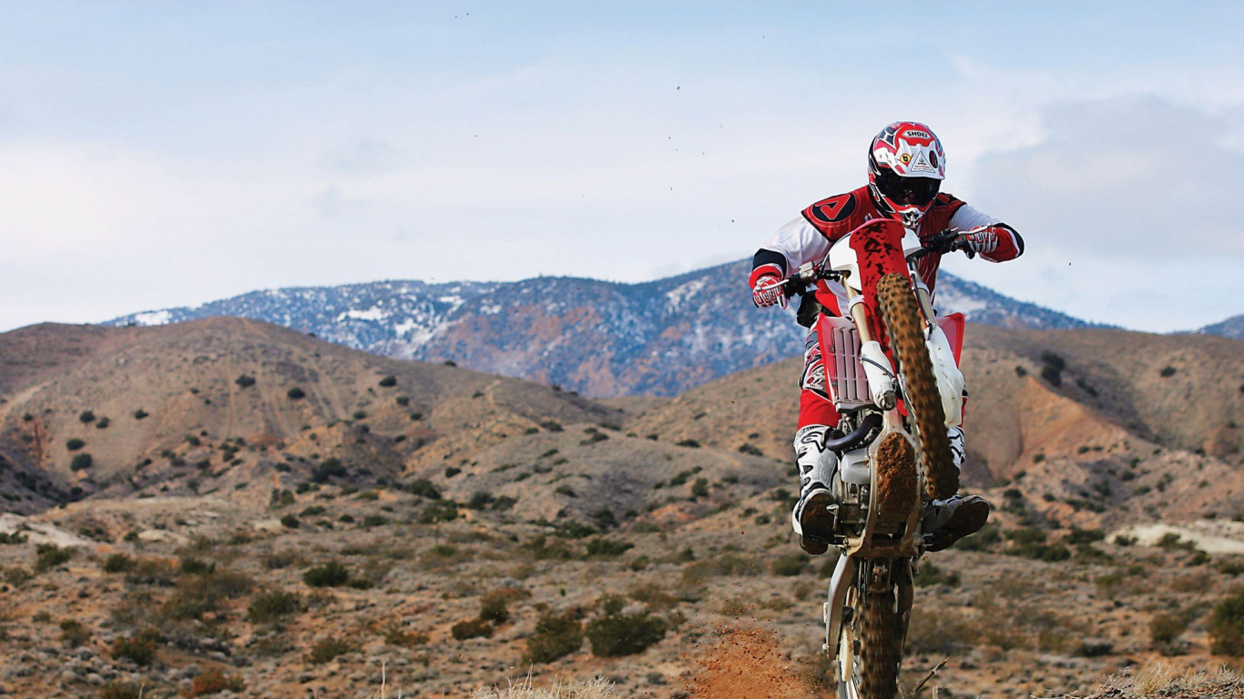 Man in Red and White Motocross Helmet Riding Motocross Dirt Bike on Brown Field During Daytime. Wallpaper in 1366x768 Resolution