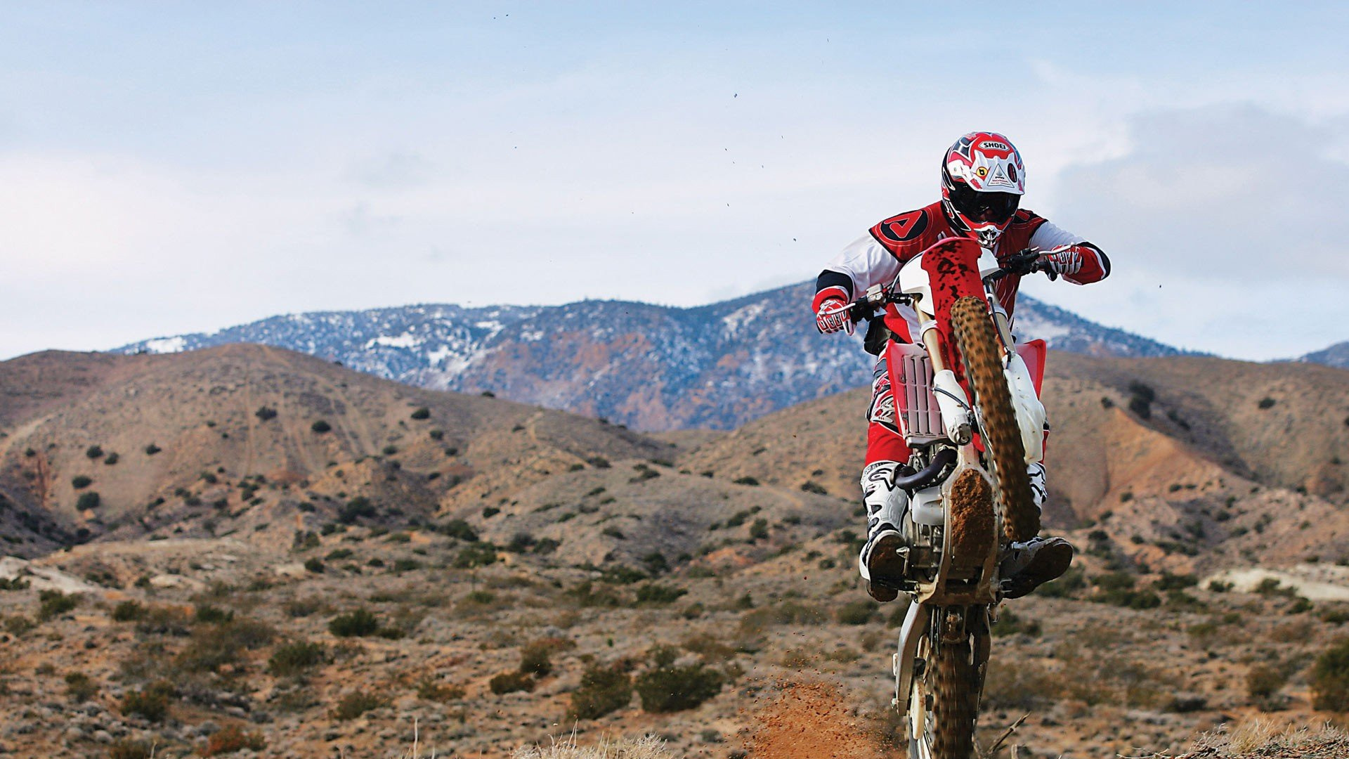 Man in Red and White Motocross Helmet Riding Motocross Dirt Bike on Brown Field During Daytime. Wallpaper in 1920x1080 Resolution